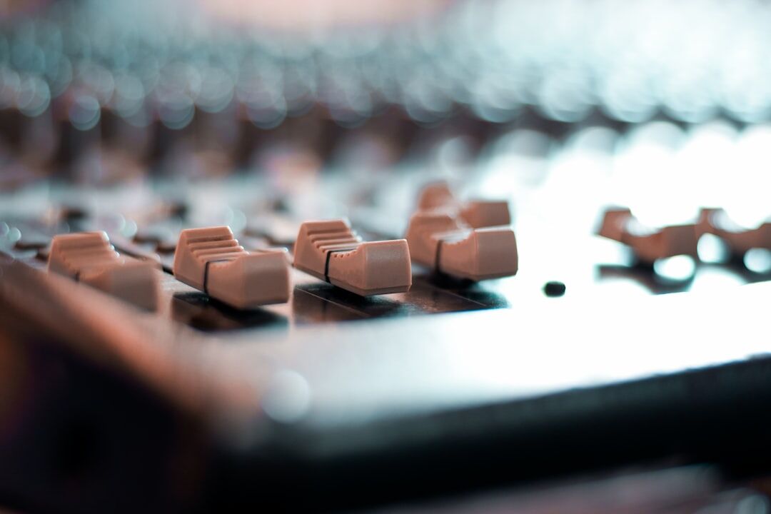 Close up of an audio mixing console with faders and knobs