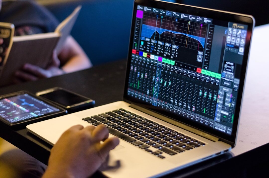 Hands editing an audio waveform on a laptop screen